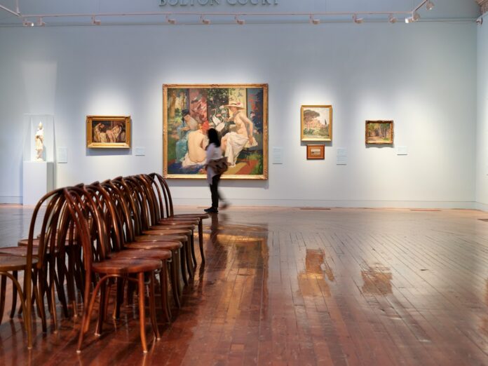 A room filled with wooden chairs and paintings