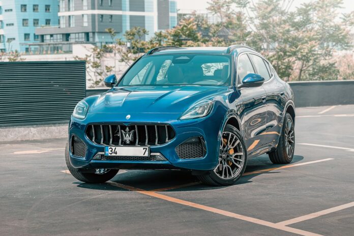 a blue masera parked in a parking lot