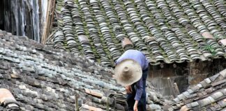person standing on roof tiles