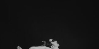 woman in black dress lying on black surface
