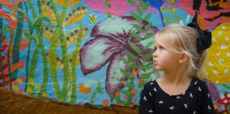 girl leaning on floral wall