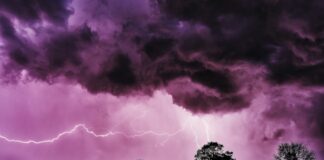 a purple sky with a lightning bolt in the distance