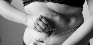 grayscale photo of woman holding her breast