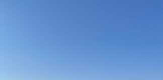 a body of water with a rocky island in the distance