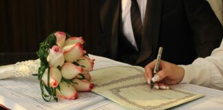 A man in a suit writing on a piece of paper