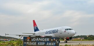 white and red air plane on brown field under white sky during daytime