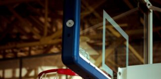 A man dunking a basketball in a gym