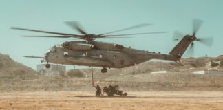 gray helicopter on brown field during daytime