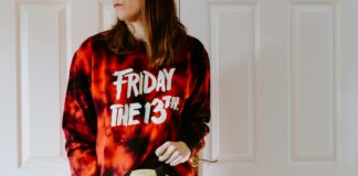 a woman in a tie dye shirt holding a dice bag
