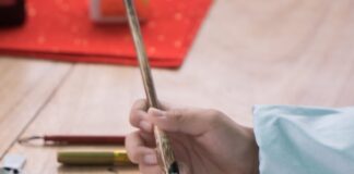 a person writing on a piece of paper with a pen