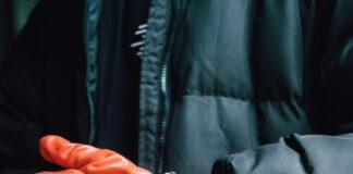 a person wearing orange gloves and a watch