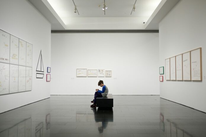 man sitting near museum painting