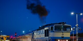 blue and red train on rail track during night time