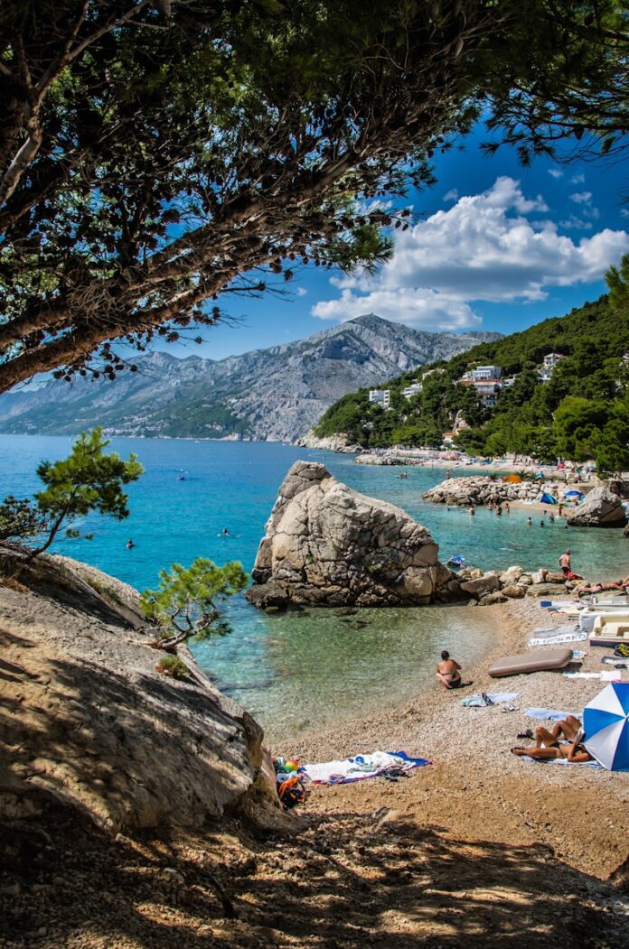 a beach with people laying on the sand and umbrellas