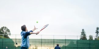 four men playing double tennis during daytime