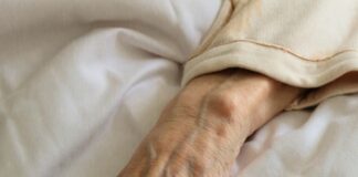persons left hand on white textile