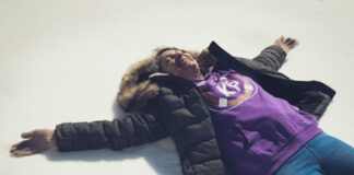 a woman laying on the ground wearing a purple shirt