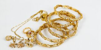 gold chain necklace on white surface