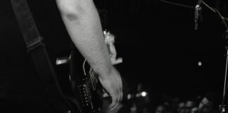 grayscale photo of person playing guitar