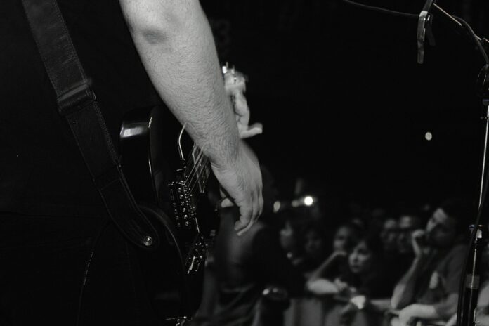 grayscale photo of person playing guitar