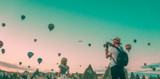 man taking photo of hot air balloons