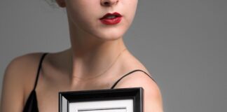 a woman in a black dress holding a framed picture