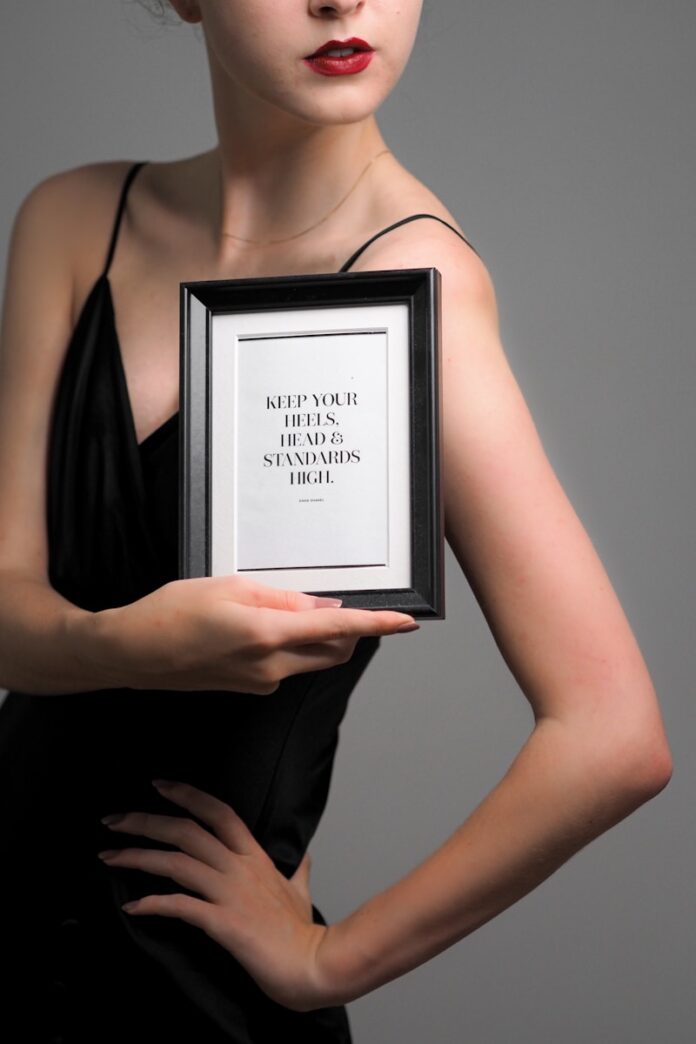 a woman in a black dress holding a framed picture