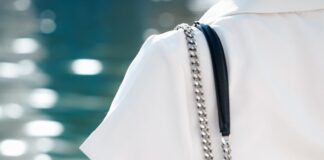 A woman in a white dress carrying a black handbag