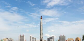 white and red tower near body of water during daytime