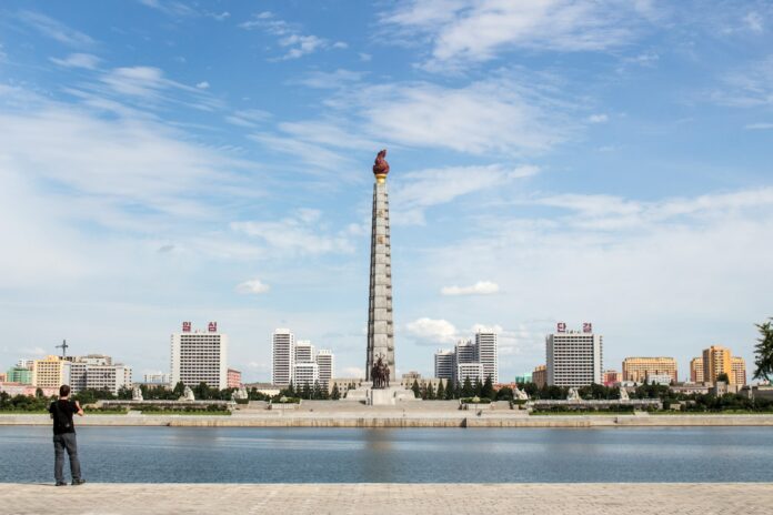 white and red tower near body of water during daytime