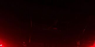 A crowd of people in a dark room with red lights