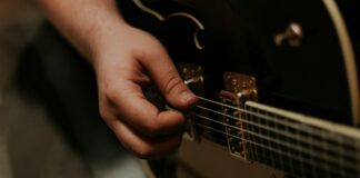 person holding black guitar