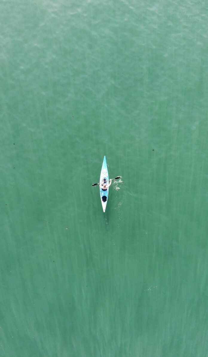 a person in a kayak in the middle of a body of water