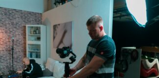 man in black and green stripe polo shirt holding black and gray cordless hand drill