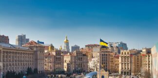 a city street filled with lots of traffic next to tall buildings