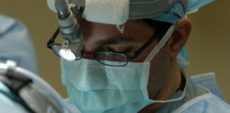 man in blue and white collared shirt wearing green face mask