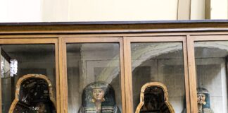 a group of carved wooden figures in a display case