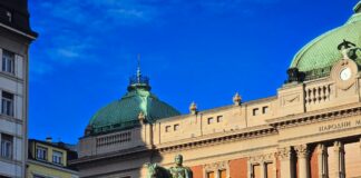 a statue of a man riding a horse in front of a building