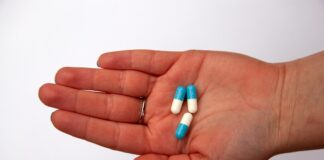 three capsules on person's palm