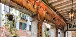 man riding on boat beside restaurant