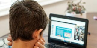 boy in gray shirt using black laptop computer