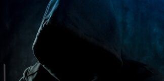 a man in a hoodie using a laptop computer