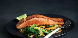 grilled fish, cooked vegetables, and fork on plate