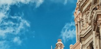 yellow and red flag hanging on white building