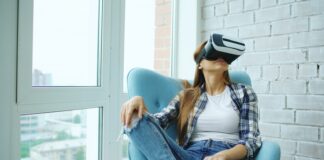 Woman wearing vr headset sitting in armchair