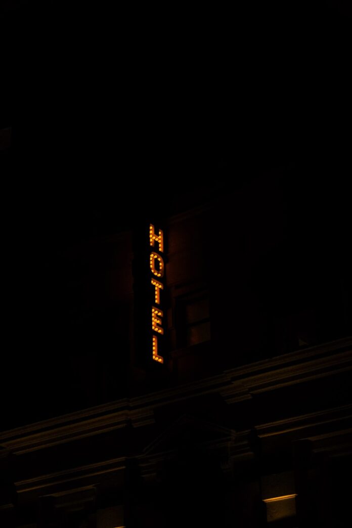 Vertical illuminated hotel sign at night