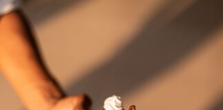 a person holding a piece of cake on a plate