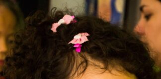 girl in white crew neck shirt with pink and white polka dots on her face