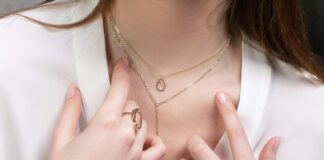 a close up of a person wearing rings and a necklace