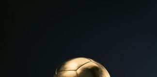 a golden soccer ball sitting on top of a rock